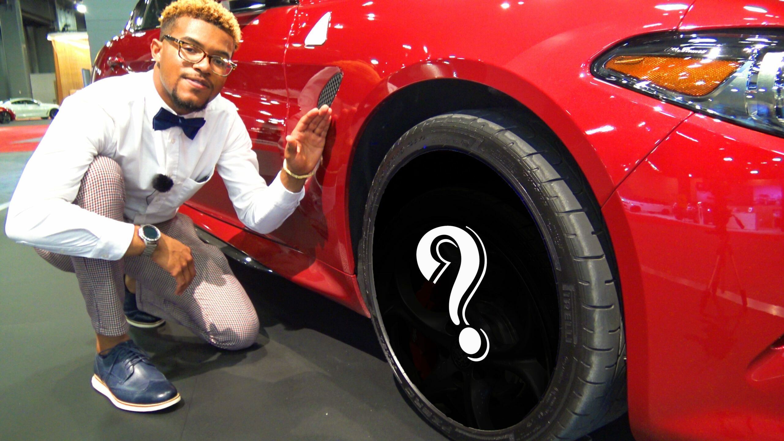 Marcus Walker next to red car (question mark covering the car's wheel/rim design).