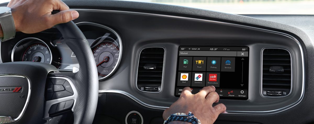 2020 Dodge Charger/Challenger UCONNECT infotainment system with man tapping screen. 

BEST Road-Trip Cars of 2020